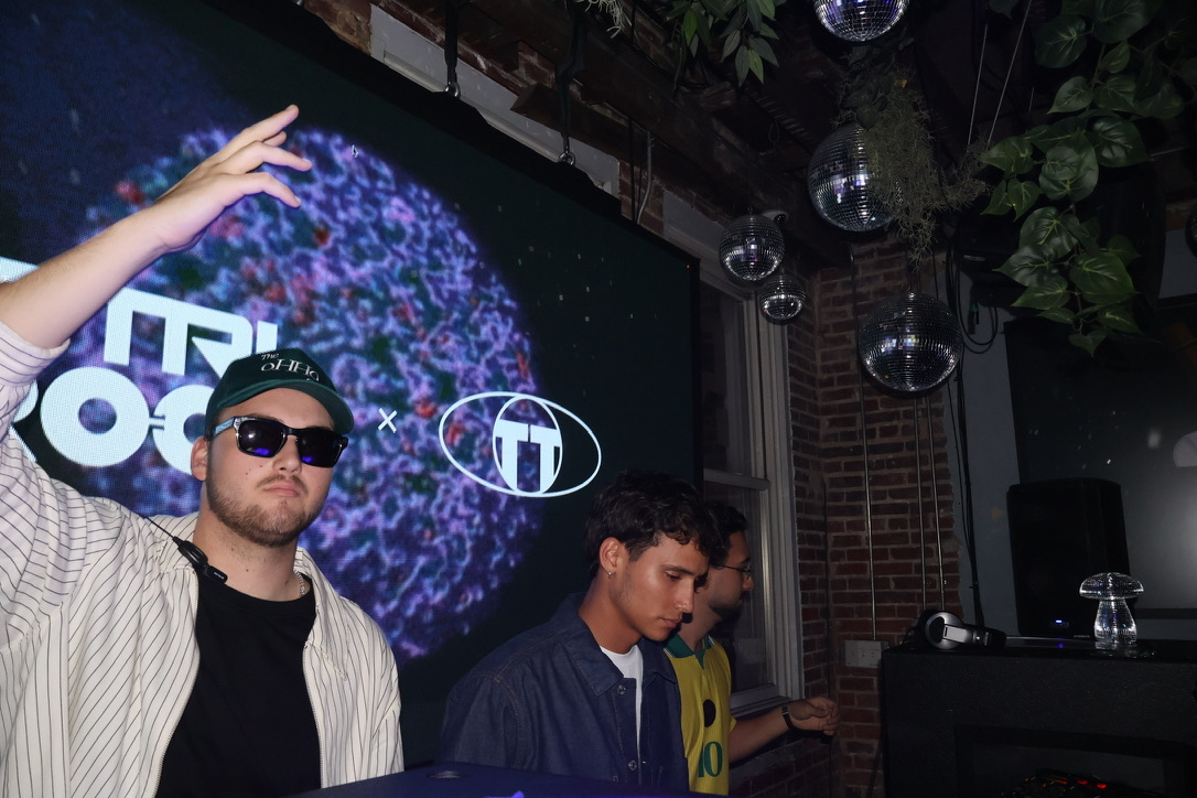 DJs behind the booth beneath disco balls and CTRL ROOM visuals