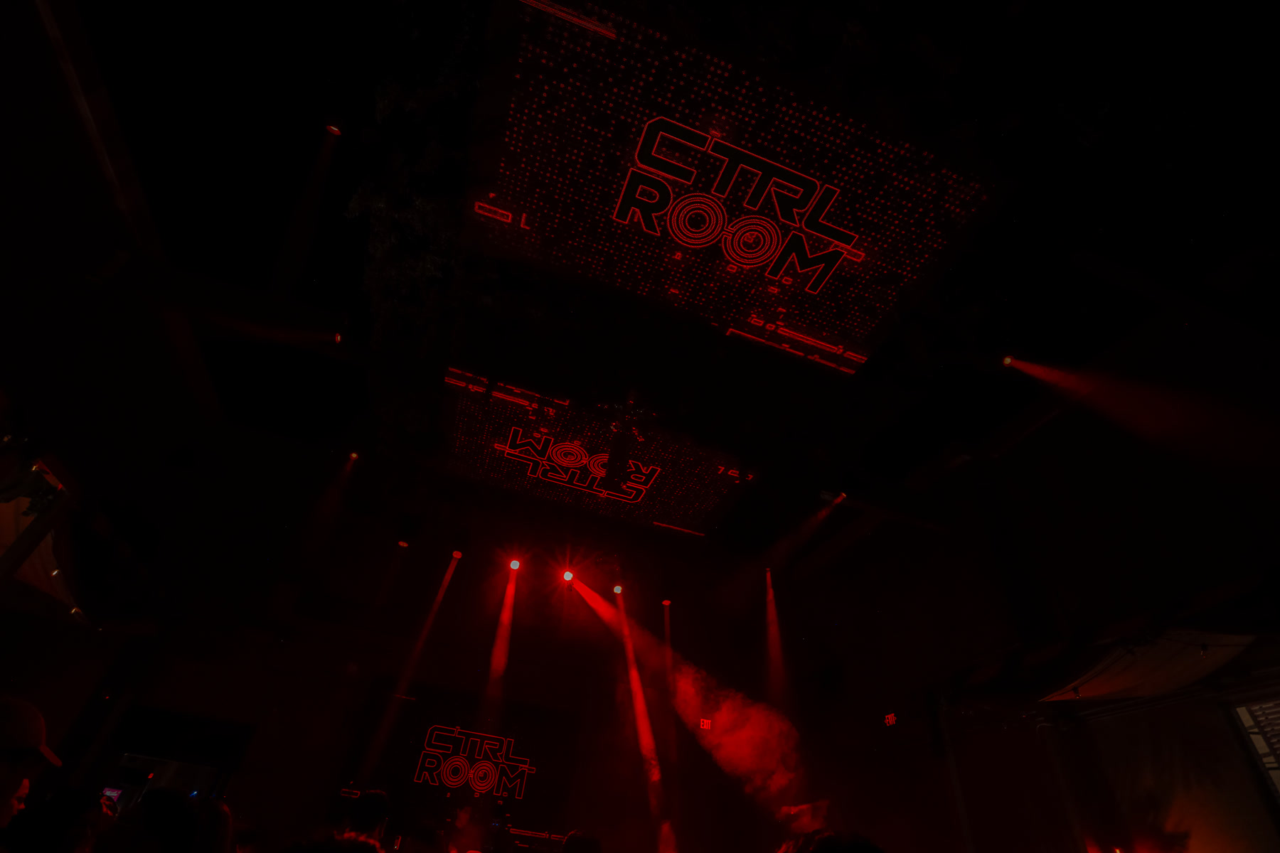 Red CTRL ROOM visuals across the ceiling above the dance floor